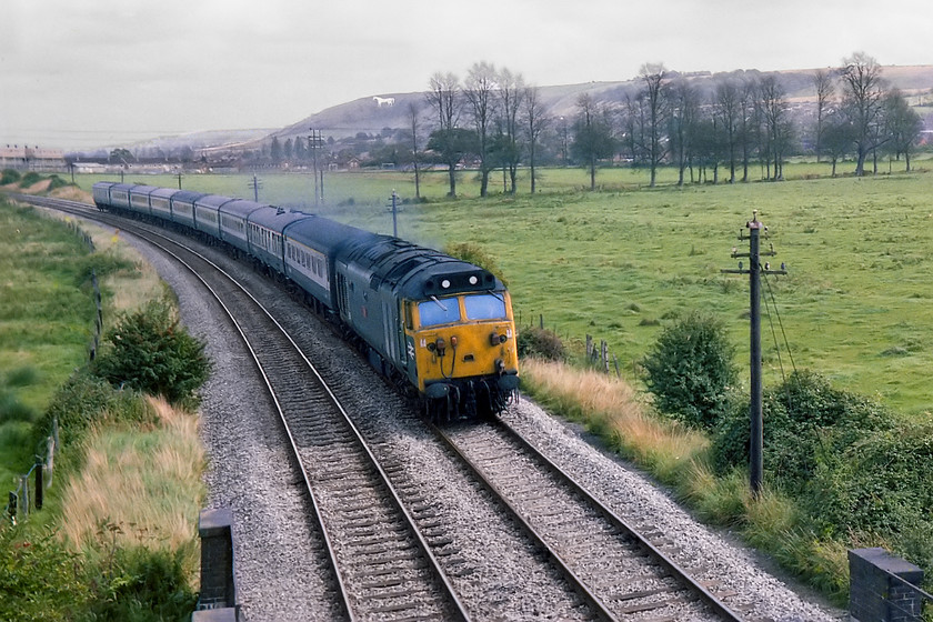 50038, 11.30 London Paddington-Penzance (1B66), The Cornish Riviera, Dilton Marsh ST856512 
 50038 Formidable sweeps around a curve on the Westbury cut-off at speed with the 1B66 11.30 Paddington to Penzance, the down Cornish Riviera. The picture is taken from a footpath that crosses the line on a bridge that also carries the Portsmouth line up towards Dilton Marsh. In the background the famous Westbury White Horse can also be seen with a row of dead elm trees in the field in the foreground, victims of Dutch elm disease. 
 Keywords: 50038 11.30 London Paddington-Penzance 1B66 The Cornish Riviera, Dilton Marsh ST856512