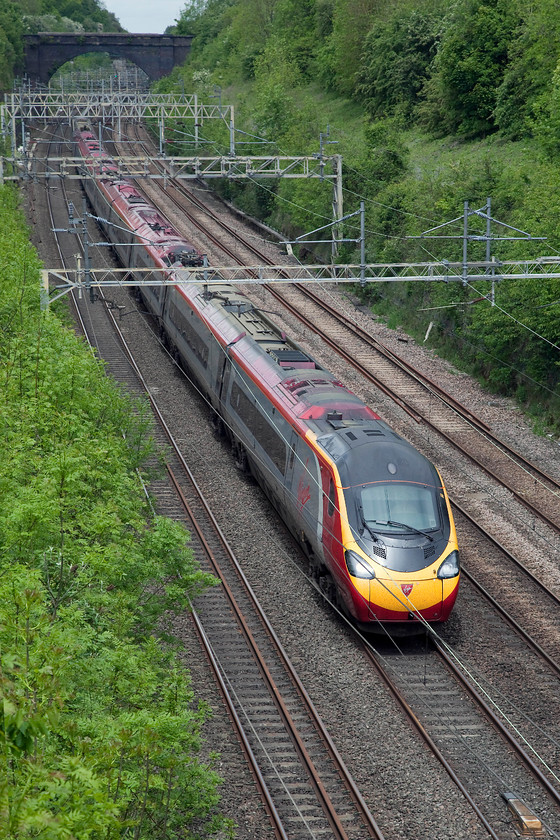 390128, VT 10.38 Liverpool Lime Street-London Euston (1A14, RT), Hyde Road Bridge 
 390128 'City of Preston' passes through Roade Cutting and is about to pass under Hyde Road Bridge in my home village of Roade with the 10.38 Liverpool Lime Street to Euston. Even though it was warm, it was one of those early summer days where the sun was trying to get put but it remained quite overcast with only half glimpses of it. 
 Keywords: 390128 1A14 Hyde Road Bridge