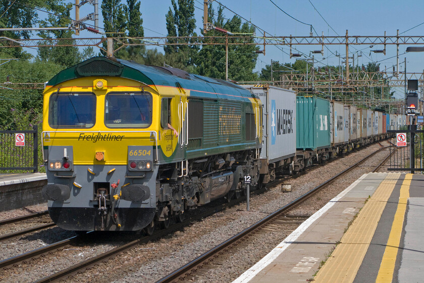 66504, 10.04 Lawley Street-Felixstowe North (4L98), Northampton station 
 Whilst this section of the WCML is busy for freight during the start and towards the end of the day from approximately 09.00 to 16.00, there is a bit of a dearth of such trains. In its new style, Freightliner livery 66504 takes the centre road through Northampton with the 10.04 Lawley Street to Felixstowe North 4L98 train. Notice the driver nonchalantly hanging his hand and forearm out of the window no doubt hoping for some cooling effect on this hot summer's morning as there is no air conditioning in the cabs of these locomotives. 
 Keywords: 66504 10.04 Lawley Street-Felixstowe North 4L98 Northampton station Freightliner