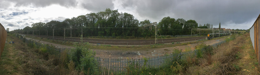 Panoramic view, site of Roade station from former Pianoforte site 
 Taken using my iPhone in panoramic mode, the WCML is seen at Roade with a class 350 heading south. This new view has been provided courtesy of the construction of a new housing estate. The land behind the fence, now occupied by a vast number of houses was previously home to the former Pianofirte/Simplex site. 
 Keywords: Panoramic view site of Roade station from former Pianoforte site