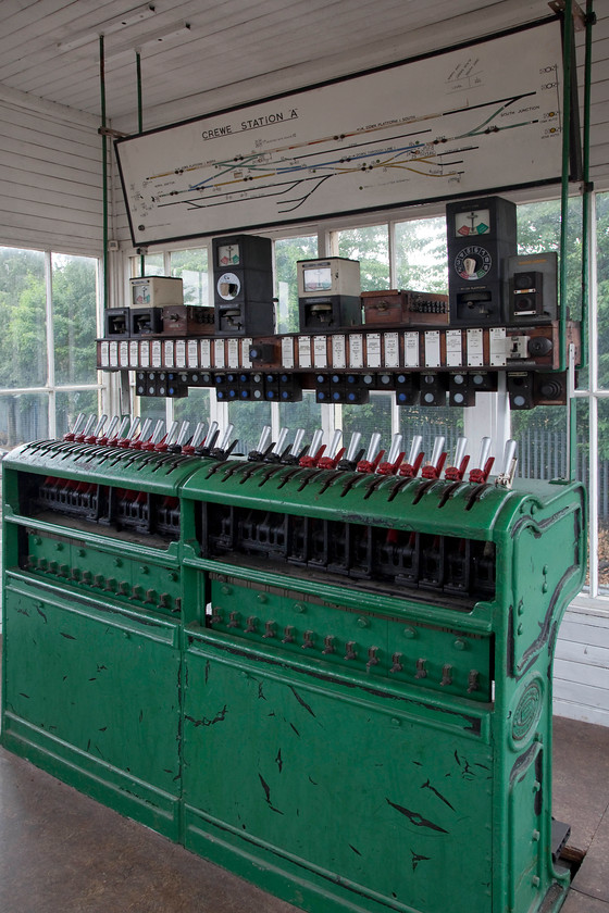 Interior, former Crewe Station A signal box, rebuilt, Crewe Heritage Centre 
 Crewe Station A signal box was a LNWR Type 5 box built in 1907. It was constructed with a flat roof so it could fit under the station canopy at Crewe between the Down Platform 1 and the Down through line 1. It was decommissioned during the Crewe rebuilding in 1985 and ended up being re-built here at the Crewe Heritage Centre. The track layout can be seen at the top along with its block instruments and the electropneumatic mini lever frame. 
 Keywords: Crewe Station A signal box Crewe Heritage Centre