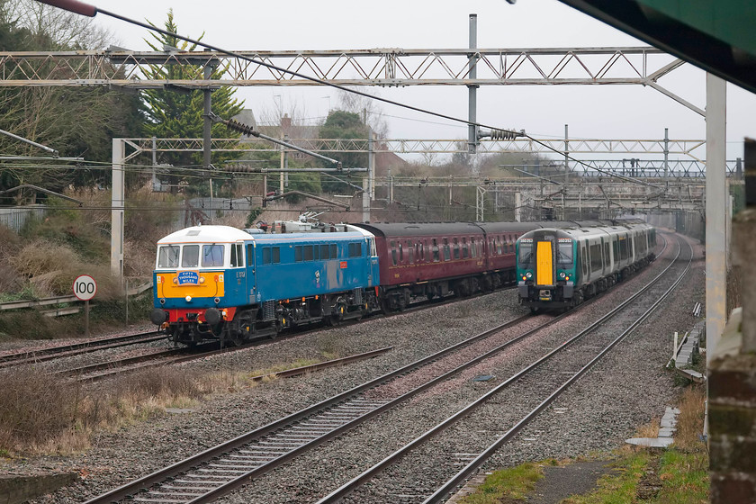 86259, outward leg of The Winter Cumbrian Mountain Express, 07.10 London Euston-Carlisle (1Z86) & 350252, LN 06.01 Crewe-London Euston (1U16, 1L), site of Castlethorpe station 
 At the site of Castlethorpe station, this was the shot that nearly didn't get taken! A class 390 had just passed northbound with the the 1S42 as 86259 was approaching, so I thought that I was safe, only then to hear a train from behind me. Luckily, 350252 was on the up fast and going at some speed so it had cleared the front of the northbound 1Z86 just in time! Notice that 86259 is not carrying its usual headboard but one stating 'Fifty Thousand Miles' presumably denoting the mileage covered by the locomotive since preservation. Can anybody confirm this? Up until 2011, 86259 had covered some 5.7 million miles in service, quite an achievement. 
 Keywords: 86259 The Winter Cumbrian Mountain Express 07.10 London Euston-Carlisle 1Z86 350252 06.01 Crewe-London Euston 1U16 site of Castlethorpe station