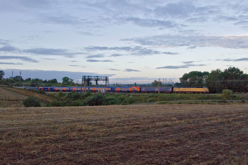 47749 & 458523, 04.26 Wembley Yard-Widness Transport Tech (5Q69, 73L), between Roade & Ashton 
 Unfortunately, the sun went behind some stubborn cloud just before the crucial time thus the lighting of what I had actually gone out to see was somewhat compromised! Travelling at a very slow speed that appeared to be forty miles per hour and under a Q code meaning it must not deviate from its route under any circumstances the 04.26 Wembley Yard to Widness Transport Tech. passes between Roade and Ashton. I suspect it was running under a Q code as a Southern unit could easily go out of gauge on unchecked track. South West Trains' 458523 is going north well away from its DC haunts for attention at Altom's facility that specialises in internal refurbishments and repaints (as per their recent work on the Pendolinos). The amazing train is being hauled by 47749 'City of Truro' with 69008 out of sight on the rear. 
 Keywords: 47749 458523, 04.26 Wembley Yard-Widness Transport Tech 5Q69 between Roade & Ashton City of Truro