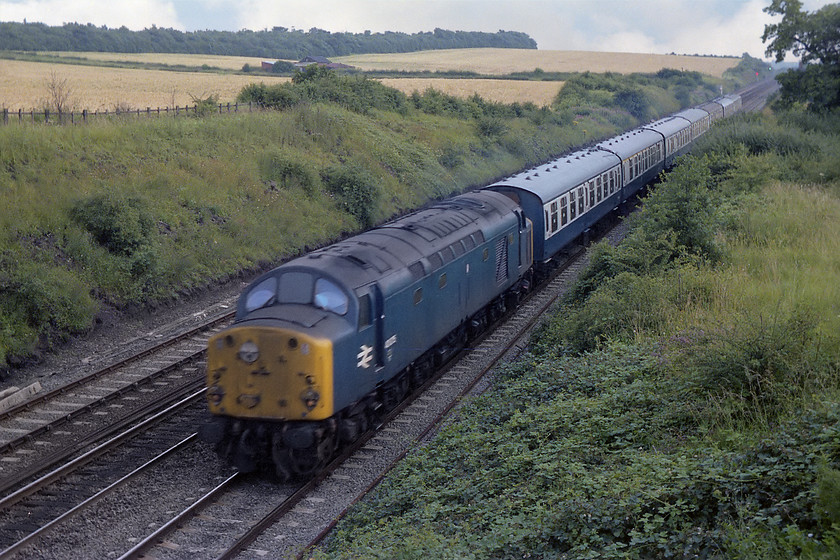 40075, unidentified down working, Eaton Wood SK723773 
 Another shot spoiled by the weaknesses of the old Exa camera, namely a maximum shutter speed of 1/150th second. The smashing rake of Mk. I stock is sharp enough but 40057 is not. The unidentified down working is seen passing Eaton Wood just south of Retford on the ECML. Studying the first coach of the formation reveals a set of round stickers stuck to every window, could this be some kind of excursion? Various sites that I have looked at, including the amazing Six Bells Junction do not list this train. 
 Keywords: 40075 down working Eaton Wood SK723773