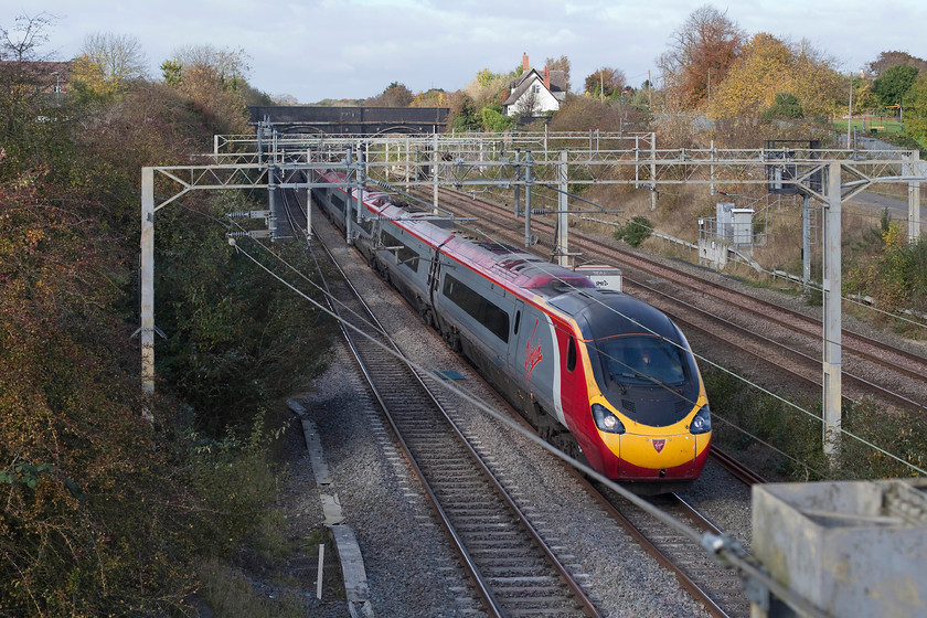 390136, VT 10.55 Manchester Piccadilly-London Euston (1A28), site of Roade station 
 390136 'City of Coventry' passes the site of Roade station with the 10.55 Manchester Piccadilly to Euston. There is nothing remaining of the station except for the station master's house painted white now a private residence at the top of the station access road. 
 Keywords: 390136 10.55 Manchester Piccadilly-London Euston 1A28 site of Roade station