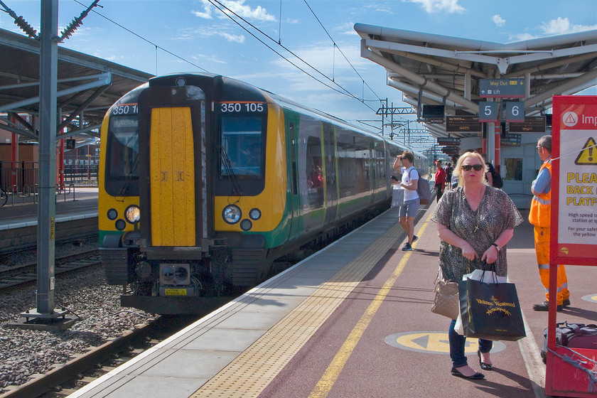 350105, LM 15.14 Birmingham New Street-London Euston (1Y58), Rugby station 
 Mrs. On The Up Fast does not look very happy and not quite able to understand why I am taking a picture of yet another London Midland Desiro as it enters Rugby station! However, she is still able to proudly show-off her latest handbag purchase made in Liverpool even if it remains in the black bag! We took 350105 working the 15.14 Birmingham New Street to Euston as far as Northampton making it our third and final train of our journey back from Lime Street. 
 Keywords: 350105 15.14 Birmingham New Street-London Euston 1Y58 Rugby station London Midland desiro