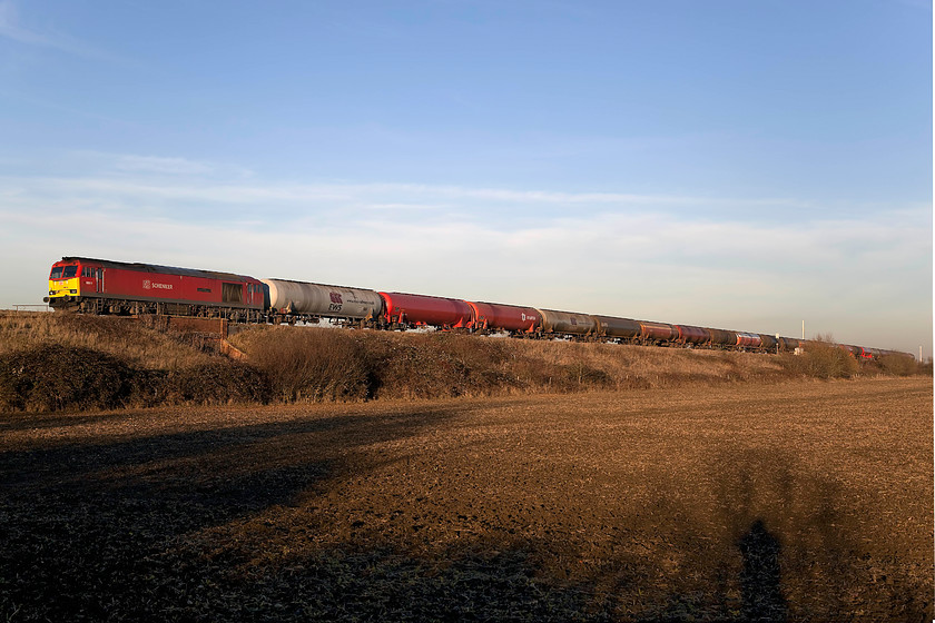 60019, 13.00 Theale-Robeston (6B33), Knighton SU278890 
 I had been tracking the progress of the daily 13.00 Theale to Robeston empty oil tanker on Real Times Trains and was wondering where I could manage to get it in full sun with no masts. As it happened, there is no evidence but for two lone and distant masts of electrification here at Knighton between Swindon and the Challow loops. Also, the line is raised on an embankment ensuring that it catches all of the late afternoon winter sunshine. 60019 'Port of Grimsby and Immingham' leads the train sedately along the GWML with HST drivers behind no doubt cursing its slow progress. Notice my shadow to the bottom right hand corner. 
 Keywords: 60019 13.00 Theale-Robeston 6B33 Knighton SU278890