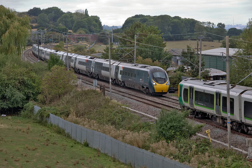 390127, VT 13.47 Liverpool Lime Street-London Euston (1A39, 1L) & Class 350 14.46 London Euston-Crewe (1U39, 4L), Banbury Lane bridge 
 Near perfect timing on the Weedon loop line west of Northampton at Banbury Lane bridge sees 390127 about to cross an unidentified Class 350 working northwards. The Pendolino is working the 1A39 13.47 Liverpool LImes street to Euston whilst the Desiro the 14.46 Euston to Crewe 'fast' service. 
 Keywords: 390127 13.47 Liverpool Lime Street-London Euston 1A39 London Northwestern Desiro14.46 London Euston-Crewe 1U39 Banbury Lane bridge