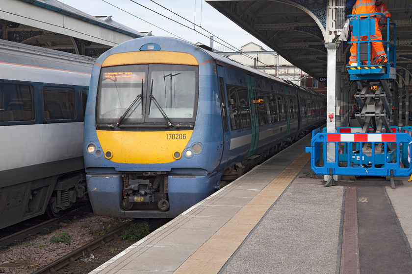 170206, LE 11.40 Norwich-Cambridge (1K73), Norwich station 
 170206 leaves Norwich with the 11.40 local stopper to Cambridge. Notice the staff in the cage of the cherry picker on the platform involved in the installation of new LED lighting. 
 Keywords: 170206 11.40 Norwich-Cambridge 1K73 Norwich station