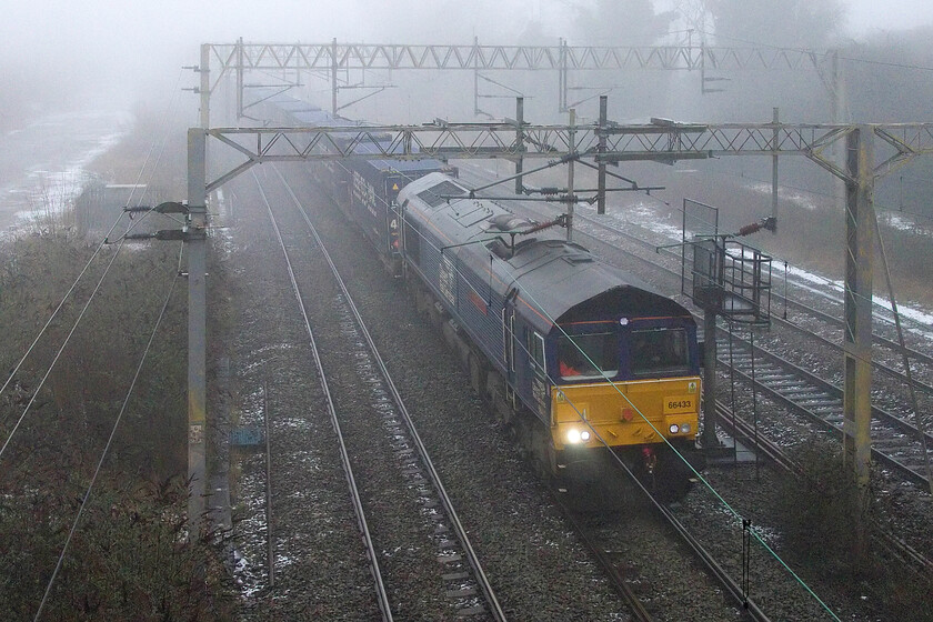 66433, 08.47 Tilbury FLT-DIRFT (4M07, 51E), site of Roade station 
 With the remnants of last night's snowfall still evident through the fog 66433 'Carlisle Power Signal Box 50th Anniversary 1973-2023' passes Roade working the 4M07 08.47 Tilbury to Daventry Tesco Express. Whilst the many purist railway photographers would not even venture out in weather like this, I firmly believe in capturing railway images in all weather conditions. 
 Keywords: 66433 08.47 Tilbury FLT-DIRFT 4M07 site of Roade station Carlisle Power Signal Box 50th Anniversary 1973-2023