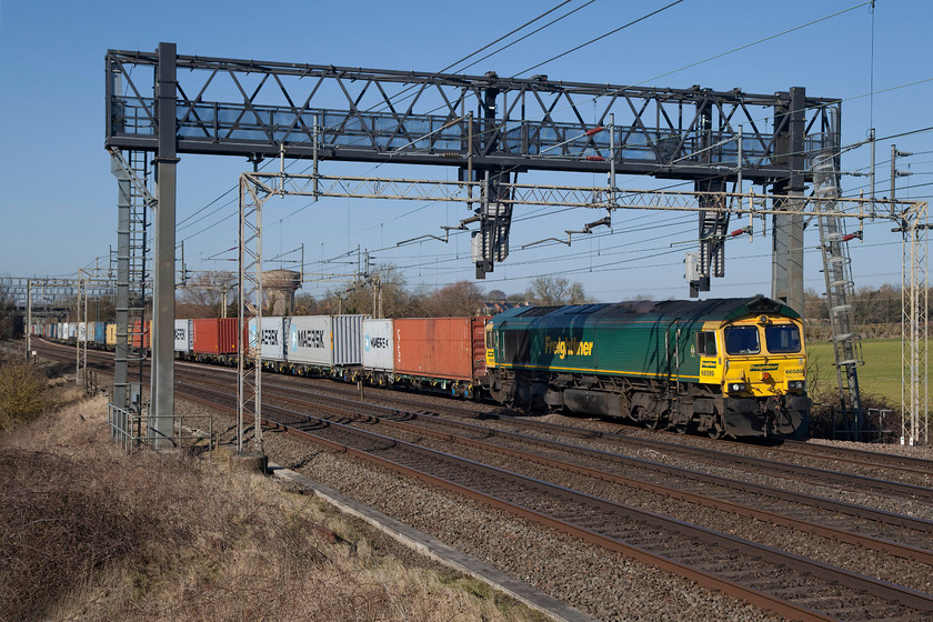 66589, 12.28 DIRFT-Wembley (4A91), Roade Hill 
 66589 begins to get some speed up after climbing the upgrade out from Northampton for some five miles or so. It was working the 12.28 Daventry (DIRFT) to Wembley Freightliner and is seen passing a freezing cold (even though it doesn't look it!) Roade Hill. 
 Keywords: 66589 4A91 Roade Hill