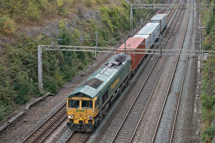 66561, 12.34 Wembley Reception Sidings-Crewe Basford Hall (7H50, 57L), Roade cutting 
 A short train but one making a heck of a row! Running as 7H50 meaning that it was limited to forty mph and this was for a reason as at least one of the wagons had a severe wheel flat that echoed around Rode cutting so much so that the passing grasped the attention of some normals crossing the bridge walking their dogs! 66561 was leading the 12.34 Wembly to Crewe Basford that I pressume was retiuring the errant flats, complete with their payload, to Crewe for repairs. 
 Keywords: 66561 12.34 Wembley Reception Sidings-Crewe Basford Hall 7H50 Roade cutting Freightliner