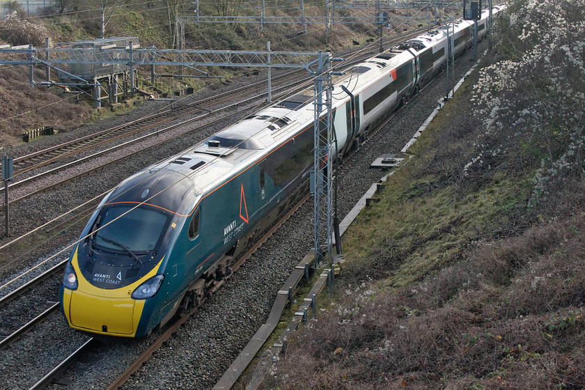 390156, VT 11.30 London Euston-Glasgow Central (1S58, 2L), Victoria bridge 
 In its shiny new Avanti West Coast livery, 390156 passes Victoria bridge just south of Roade on the WCML forming the 11.30 Euston to Glasgow Central 1S58 service. I'm glad that the designers of this livery have retained some of the white as left by Virgin when they 'stripped' the trains' previous identity in the run-up to the change of franchise. Without these areas and the other bright flashes of orange, the Pendolinos would have looked very drab and rather like GWR's awfull livery as applied to their stock. 
 Keywords: 390156 11.30 London Euston-Glasgow Central 1S58 Victoria bridge Avanti West Coast Pendolino