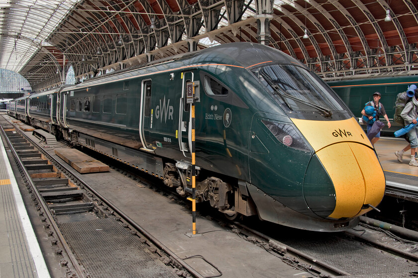 800014, GW 10.17 Castle Cary-London Paddington (1A61, 17L), London Paddington station 
 800014 'Edith New' stands on the blocks at Paddington having arrived with the 1A61 10.17 ex Castle Cary. Edith New was a Swindon born (hence the significance for a GWR train to be so named) suffragette who was one of those first to use vandalism as a form of protest. This included putting stones down the droplights of train carriage windows causing damage to the glass; I suspect that GWR would take a very dim view of vandalism to their new trains today but at least this form of protest could not be replicated due to the lack of droplights! Notice the waery-looking festival goers making their way along the platform. Try as I might I have not been able to find out where they were returning from, Glastonbury was two weeks previously! 
 Keywords: 800014 10.17 Castle Cary-London Paddington 1A61 London Paddington station GWR IET Edith New