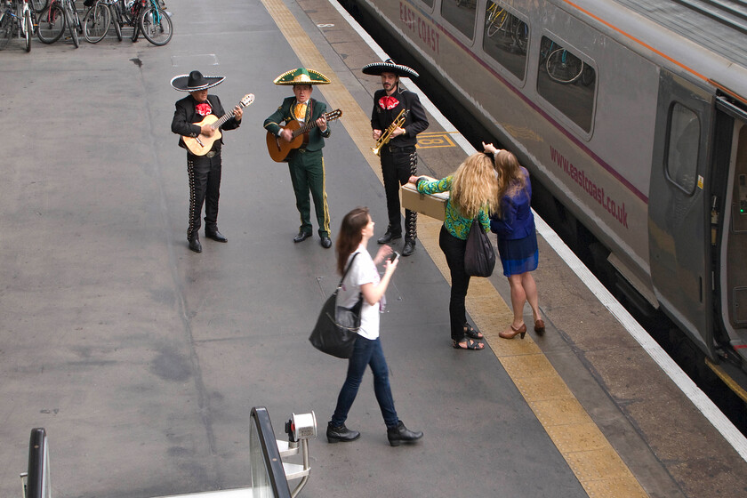 Band playing, welcoming singles aboard the 1Z91 'Love Train', London King's Cross station 
 A Mexican trio plays on the platform at King's Cross station filling the grand train shed with a slightly bizarre echoed sound! They were there to welcome singles aboard the 1Z91 'Love Train' with staff busying themselves in preparation for the arrival of customers hopeful of finding love aboard! The train left King's Cross at 10.14 for a return trip to York giving passengers plenty of time to meet that 'special friend! 
 Keywords: Band playing welcoming singles aboard the 1Z91 Love Train London King's Cross station