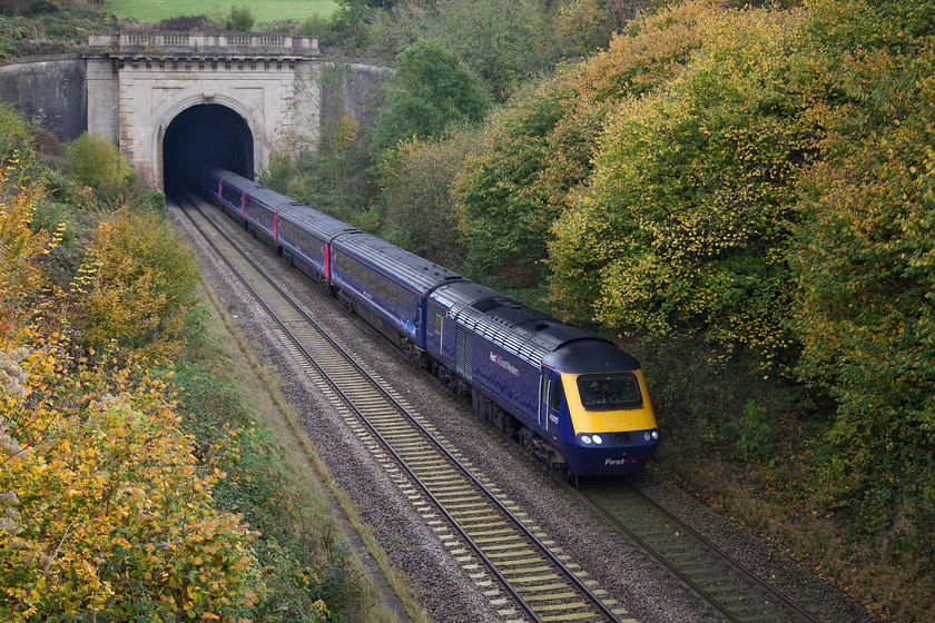 43015, GW 10.00 London Paddington-Paignton (1C09), Box, A4 road bridge 
 43015 emerges from the depths of Box tunnel. The tunnel was opened, without great pomp in 1841, having taken just four years to construct. The west portal, seen here, was completed sometime after the tunnel's opening and is built to a grand classical style, the east portal is more modest being built in brick, both are Grade II listed. 
 Keywords: 43015 10.00 London Paddington-Paignton 1C09 Box, A4 road bridge