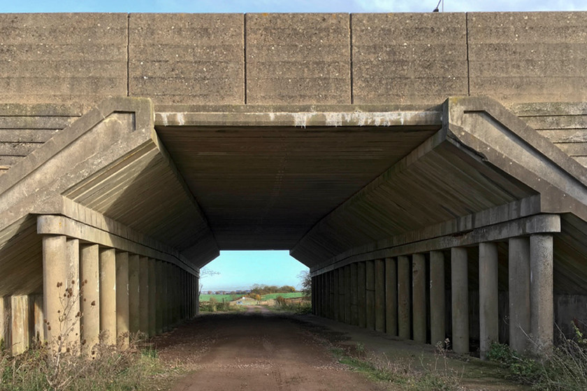 SMJ trackbed, M1 underbridge SP781524 
 A picture that clearly illustrates the interesting design of the M1 bridge that crossed the SMJ railway between Roade and Piddington. If one is travelling on the motorway, this bridge is crossed 1.8 miles south of junction 15 for Northampton. This style of reinforced concrete bridge is typical of the type used when this section of the M1 was built in the late 1950s. It's interesting to note that this section of the M1 opened on 1st November 1959 but that the railway it was crossing at this point had closed seventeen months earlier in June 1958! 
 Keywords: SMJ trackbed M1 underbridge SP781524