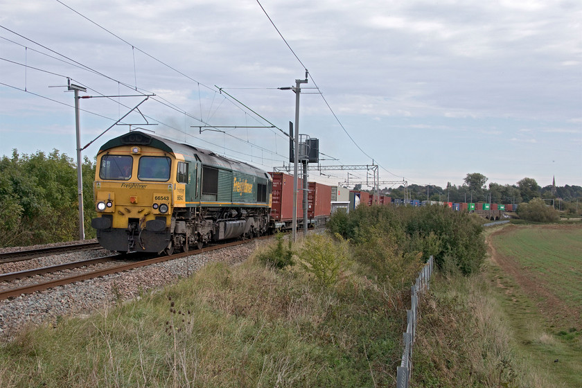 66543, 09.12 Felixstowe North-Trafford Park (4M63, 45L), Wilson's Crossing 
 With the spire of Kingsthorpe's St. John the Baptist's church on the skyline 66543 leads the 4M63 09.12 Felixstowe to Trafford Park Freightliner past Wilson's Crossing. This spot has always been reasonably open but the growth of the large bush adjacent to the signal post is beginning to compromise it.

The next time that I was to photograph this locomotive was at the same spot but looking north and on a very cold day and still in the grip of COVID pandemic, see..... https://www.ontheupfast.com/p/21936chg/30002766605/x6-66543-05-00-trafford-park-felixstowe 
 Keywords: 66543 09.12 Felixstowe North-Trafford Park 4M63 Wilson's Crossing Freightliner