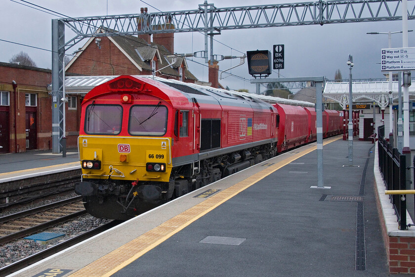 66099, 09.09 Radlett Redland-Mountsorrel Sidings (4D34, 1L), Kettering station 
 Standing in the pouring rain now such is the devotion to our hobby! 66099 #WeStandWithUkraine passes at speed on the down-slow line through Kettering station. The smartly turned-out DB Cargo Class 66 is leading the regular 09.09 Radlett Redland to Mountsorrel empty stone train composed of converted coal hoppers. This working is simply referred to by local spotters on the MML as The Redlands. 
 Keywords: 66099 09.09 Radlett Redland-Mountsorrel Sidings 4D34 Kettering station #WeStandWithUkraine