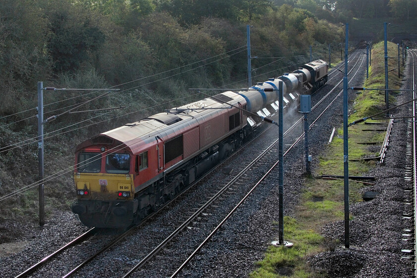 66041 & 66104, 23.17 Toton TMD-West Hampstead Thameslink (3J92, 6E), Park Road bridge TL020390 
 66041 brings up the rear of the 3J92 23.17 Toton to West Hampstead RHTT with 66104 leading. This working is nearing its termination in North London having been in operation throughout the night and having passed this spot, on the three other tracks, three times previously. Taken photographs into the sun is not my chosen practice but it does highlight the high-pressure water being directed on to the rail head. The train is about to pass into the eastern Ampthill tunnel that can be seen in the distance. 
 Keywords: 66041 66104, 23.17 Toton TMD-West Hampstead Thameslink 3J92 Park Road bridge TL020390 Squirter RHTT