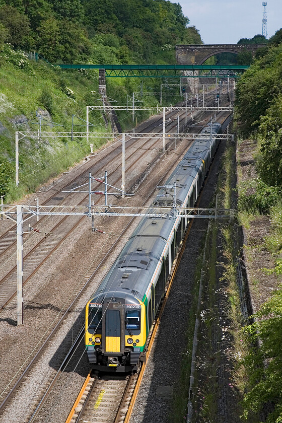 350234 & 350119, LM 10.08 Northampton-London Euston, Roade Cutting 
 350234 and 350119 pass through Roade cutting working the 10.08 Northampton to Euston London Midland service. Whilst the sun is out it is clear that there is some cloud about given the shady patches behind the train. 
 Keywords: 350234 350119 10.08 Northampton-London Euston Roade Cutting London Midland Desiro