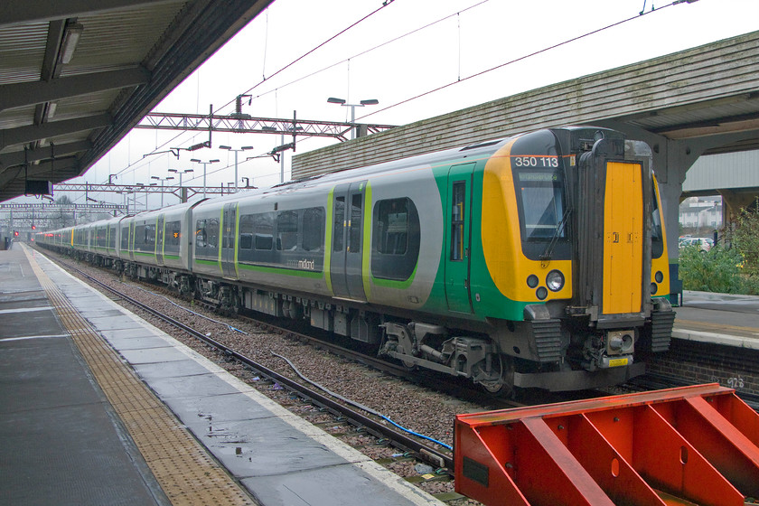 350113, 350237 & 350115, stabled, Northampton station 
 On a wet Sunday afternoon, three London Midland Desiros stand stabled at Northampton station awaiting their next duties. In order, 350113, 350237 and 350115 are seen in this utterly dismal scene! 
 Keywords: 350113 350237 350115 stabled Northampton station London Midland LM Desiro