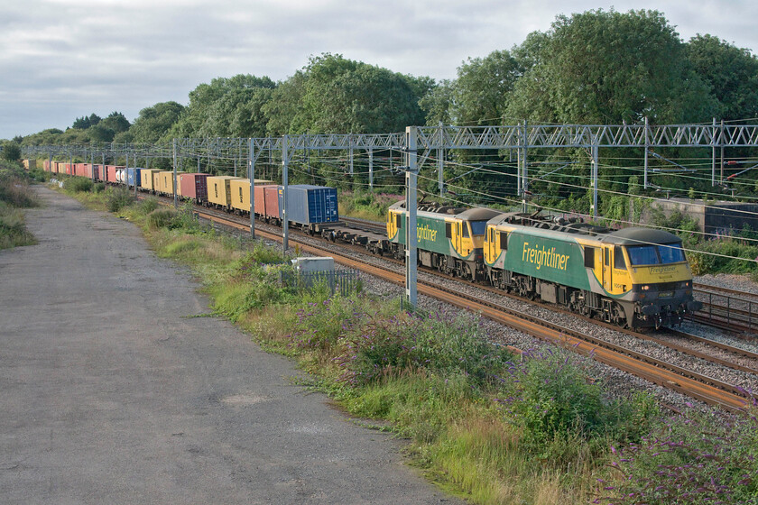 90045 & 90042, 02.50 Felixstowe North-Garston (4M45, 50E), site of Roade station 
 I have tried numerous times, to no avail, to capture the double-headed 4M45 02.50 Felixstowe to Garston Freightliner and aiming to get both locomotives in between electrification masts rather than the second one being split by an upright. Locating a spot where the masts are slightly further apart than standard appears to be the only way that I will succeed! Passing the site of Roade station, 90045 and 90042 lead the 02.50 Felixstowe North to Garston Freightliner service. 
 Keywords: 90045 90042 02.50 Felixstowe North-Garston 4M45 site of Roade station Freightliner