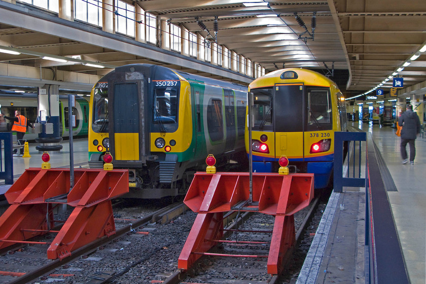 350237, LM 14.04 London Euston-Tring (2T65) & 378230, LO 13.50 London Euston-Watford Junction (2D74), London Euston station 
 Despite the overtly gloomy atmosphere at Euston station created by the misguided brutalist architectural design emanating from the 1960s when the sun is out and streaming through the few windows the mood of the place does improve somewhat. In this view where natural light prevails 350237 and 378230 wait at the blocks. The London Midland unit will soon work the 2T65 14.04 all stations stopper to Tring whilst the dual voltage Capitalstar should already have left working the 13.50 2D74 to Watford Junction. 
 Keywords: 350237 14.04 London Euston-Tring 2T65 378230 13.50 London Euston-Watford Junction 2D74 London Euston station London Midland Desiro London Overground