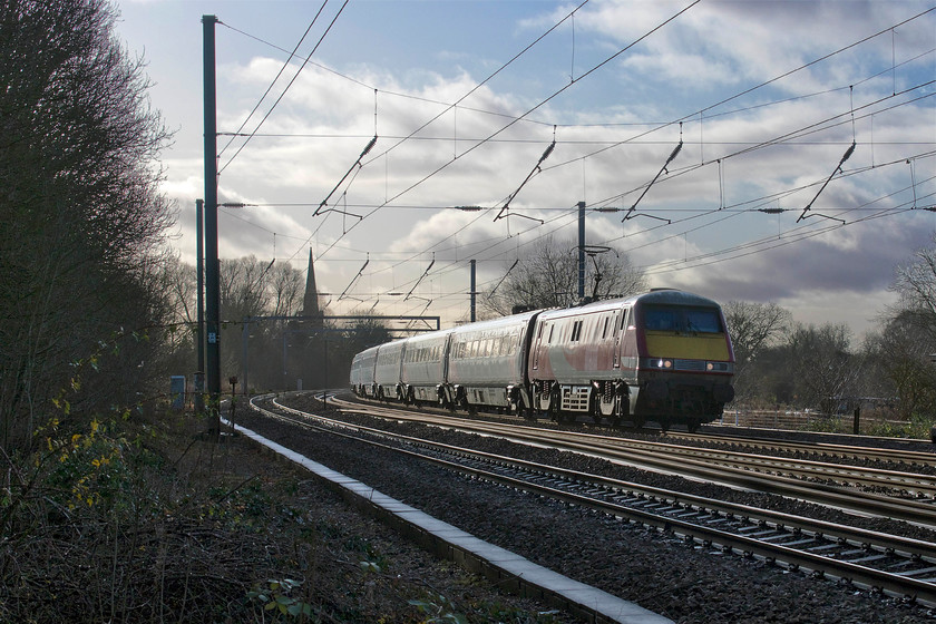 91113, GR 11.30 London King`s Cross-Edinburgh (1S15, 4L), Gill`s Crossing 
 With the spire of St. Peter's church in Offord D'Arcy silhouetted against the winter sky, 91129 leads the 1S15 11.30 King's Cross to Edinburgh. I was surprised that this particular service has not gone over to Azuma so was not quite ready when it appeared around the reverse curve on the approach to this location at Gill's crossing. 
 Keywords: 82213 91129 10.04 York-London King`s Cross 1Y82 Gill`s Crossing LNER Offord Cluny Offord D'Arcy