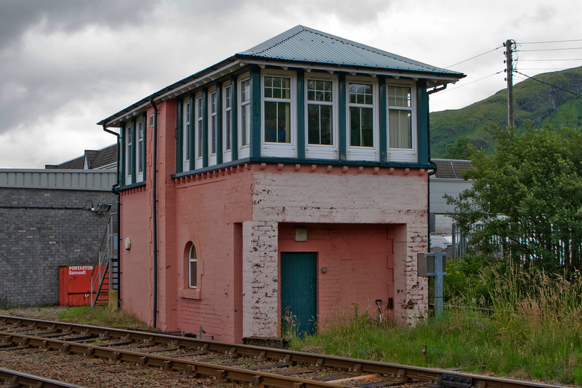 Fort William Junction (ex. Mallaig Junction) signal box (NB,1849) 
 Fort William Junction signal box is a North British style 6b opened in 1894 and fitted with a thirty lever frame also fitted with an NX Panel for the controlling the signalling into the station some two miles from where it is located. The box is located in the vee of the Mallaig branch (in the foreground) and the Glasgow line behind. As well as being named Fort William Junction from March 1988, it was also been Mallaig Junction and prior to that in 1901 Banavie Junction. Please note that the colour of the brickwork is not due to a camera colour shift issue but that it really has been painted in some sort of strange semi-pink paint! 
 Keywords: Fort William Junction Mallaig Junction signal box North British