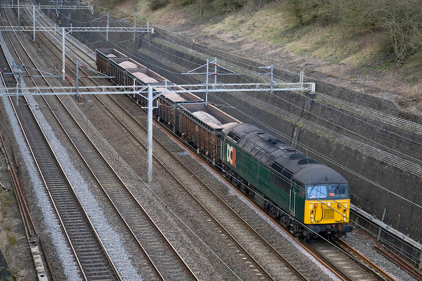 56303, 11.40 Chaddesden Sidings-Willesden Euroterminal (6M56), Roade cutting 
 Running late this what I had rushed home from work for! DCRail's (DCR or Devon & Cornwall Railways LtD) 56303 tows a short ballast train through Roade cutting heading to London. The 56 is hauling just five JRA Tiphook wagons of the type that have had their height extended two years ago to accommodate more scrap for which they are ostensibly designed. However, as can be seen here they are also suitable for carrying ballast or stone, in this case as the 6M56 Caddesden to Willesden Euroterminal. 
 Keywords: 56303 11.40 Chaddesden Sidings-Willesden Euroterminal 6M56 Roade cutting DCR DC Rail