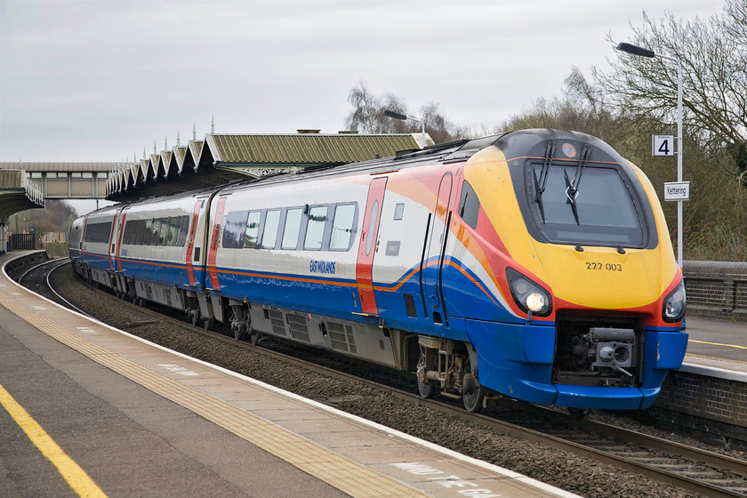 222003, EM 09.58 London St. Pancras-Sheffield (1F21), Kettering station 
 2220003 'Tornado' takes the sharp curve at Kettering station at full line speed working the 09.58 St. Pancras to Sheffield East Midlands Trains service. Note the 'nameplate' attached to the Meridian just in front of the first passenger door. I put the word nameplate in inverted commas as it is actually a vinyl stuck to the side of the unit rather than a cast plate as we are more used to; this is what our modern railway has come to! 
 Keywords: 222003 09.58 London St. Pancras-Sheffield 1F21 Kettering station East Midlands Trains Meridian Tornado