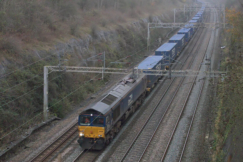 66429, 10.02 Tilbury-DIRFT (4M07, 25E), Roade cutting 
 66429 emerges from the fog in Roade cutting leading the 4M07 10.02 Tilbury to Daventry Tesco service. After a balmy and lovely autumn that found me out and about wearing shorts just two weeks previously the weather has returned to type with a vengeance being chilly and damp. 
 Keywords: 66429 10.02 Tilbury-DIRFT 4M07 Roade cutting Tesco Express