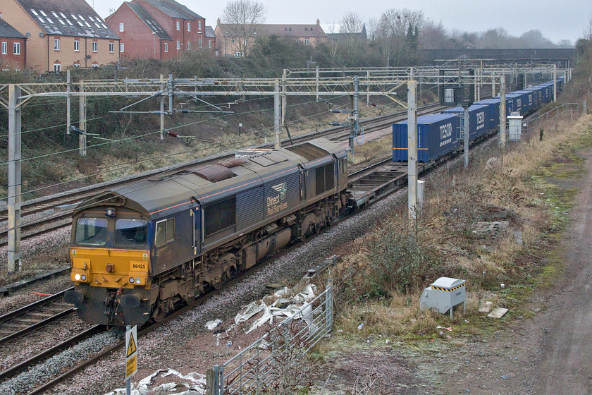 66425, 13.51 DIRFT-Ripple Lane (4L48, 57L), site of Roade station 
 DRS usually makes an effort to keep its locomotives looking smart but standards appear to be slipping in the case of 66425! It is seen looking particularly grubby as it passes Roade with the 4L48 13.51 Daventry to Ripple Lane Tesco Express service. Like other freights observed on this day, it was very well loaded with very few empty flats. 
 Keywords: 66425 13.51 DIRFT-Ripple Lane 4L48 site of Roade station DRS Direct Rail Services