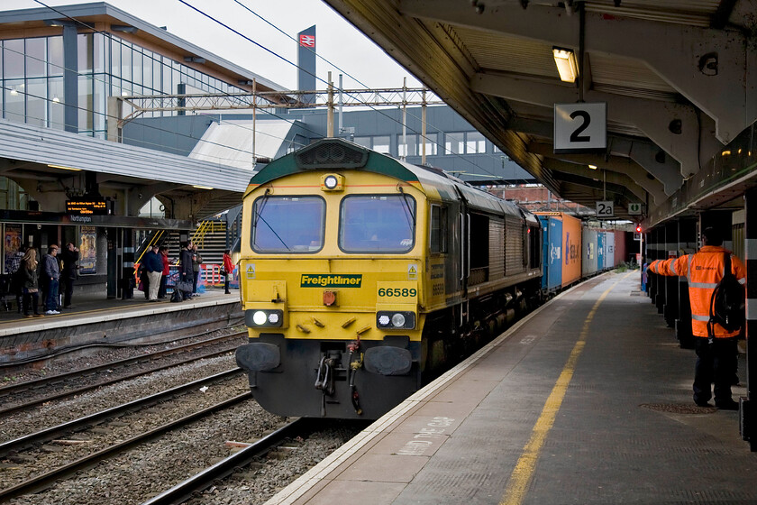 66589, 03.00 Felixstowe North-Lawley Street (4M86), Northampton station 
 With a welcome wave from a DB Schenker driver to a Freightliner employee, 66589 leads the 4M86 03.00 Felixstowe to Lawley Street through Northampton station. This Class 66 has led a pretty anonymous life since it arrived on our shores in April 2007 and I suspect that it will go on doing what was designed to do for many years to come. 
 Keywords: 66589 03.00 Felixstowe North-Lawley Street 4M86 Northampton station