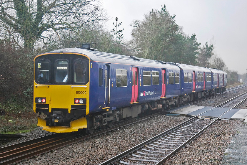 150002, GW 14.10 Reading-Basingstoke (2J41), Mortimer station 
 150002 leaves Mortimer station working the 14.10 Reading to Basingstoke local service. Mortimer is one of two intermediate stations between the two towns, a rail distance of just over sixteen miles. Once again, it is teeming with rain and the mid-winter light has all but gone. 
 Keywords: 150002 GW 14.10 Reading-Basingstoke 2J41 Mortimer station First Great Western Great Westen Railway Sprinter