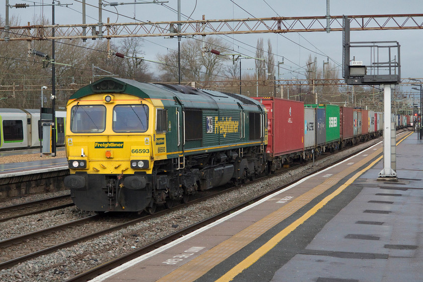 66593, 05.01 Trafford Park-Felixstowe N (4L97), Northampton station 
 With just a faint glimpse of winter brightness, 66593 '3MG Mersey Multimodal Gateway' passes through the centre road at Northampton station hauling the 4L97 05.01 Trafford Park to Felixstowe North Freightliner. As is usual with this working, there were very few empty flats. Despite the gloom, I like winter shots like this, they really evoke the mood of the season through their drab and grey light. 
 Keywords: 66593 05.01 Trafford-Park Felixstowe N Freightliner 4L97 Northampton station