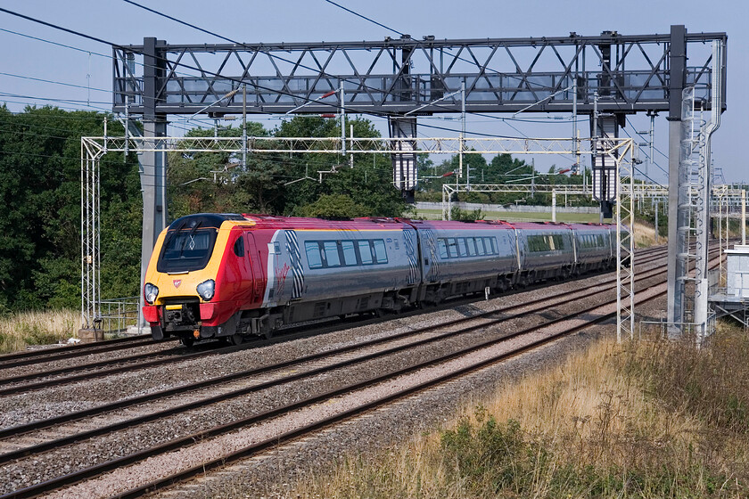 221110, unidentified up working, between Roade & Ashton 
 Shattering the peace and quiet of the Northamptonshire countryside near Roade with its five Cummins QSK19-R engines at full chat an unidentified Virgin West Coast service heads south. 221110 is one of a fleet of twenty-one units operated by Virgin on various routes along the WCML. 
 Keywords: 221110 between Roade & Ashton Virgin West Coast Voayager