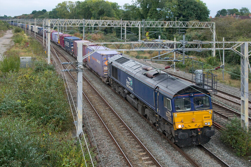 66432, 10.50 Tilbury Docks-DIRFT (4M07, RT), site of Roade station 
 The 4M07 10.50 Tilbury Docks to Daventry (DIRFT) passes Roade led by 66432. I have precious few photographs of this particular DRS Class 66 with it evading my camera! Notice the growth of undergrowth to the left of the train. This was completely cleared two years ago illustrating a situation that Network Rail faces everywhere! 
 Keywords: 66432 10.50 Tilbury Docks-DIRFT 4M07 site of Roade station DRS Direct Rail Services