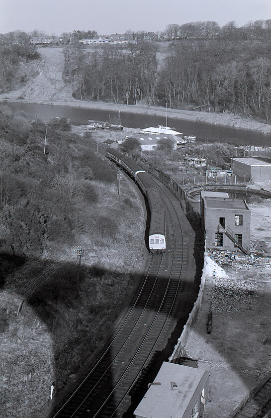 DMU, unidentified up working, Larpool viaduct 
 With the shadow of the impressive Larpool viaduct below the River Esk is seen not far from where it enters the sea through Whitby Harbour. A pair of first-generation DMUs get underway heading towards Grosmont, Battersby and then Middlesborough. The leading DMU is a three-car Class 101 but I am not sure what class the trailing set is. The former rail-connected derelict industrial site to the right is Whitby's former gasworks. Interestingly, from 1960 it was converted to use natural gas that was piped in from an extremely small offshore site. It provided Whitby's gas for some years before closure came in the early 1970s. With no road access, the site remains derelict and very overgrown after becoming the home to the excentric environmentalist campaigner Fif Robinson who died in 2006. 
 Keywords: DMU unidentified up working Larpool viaduct First generation Class 101 DMU