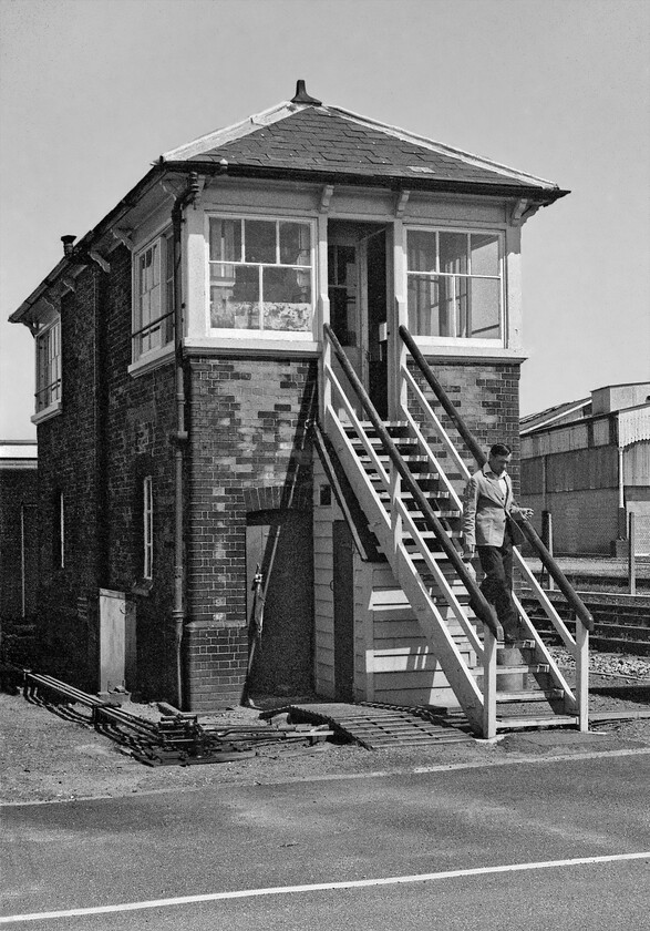 Truro signal box (GWR, 1889) 
 With its level crossing located between the platform end and the signal box this spot at Truro is a busy one similar to the layout just north of Exeter St. David's station. I took this photograph that shows the change over of shift at 14.00 with the signalmen descending the steps as he comes off-shift. The box is a GWR Type 7A structure dating from 1889. At the time of writing (2022) the box is still in use but the inevitable plans have recently been announced for the resignalling of the entire route from Plymouth westwards so its time is clearly numbered. 
 Keywords: Truro signal box GWR, 1889