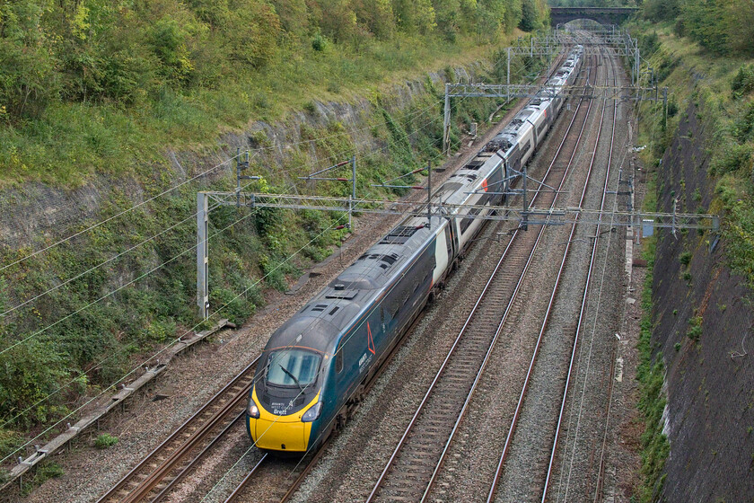 390129 VT 14.51London Euston-Glasgow Central (1S78, 6L), Roade cutting 
 Taking the slow line through Roade cutting due to the closure of the fast for engineering works 390129 'City of Stoke-on-Trent/Brett' works the 14.51 Euston to Glasgow Anglo-Scottish 1S78 express. As well as having the long-held name 'City of Stoke-on-Trent' 390129 also has the name Brett applied to the cab ends in the memory of former duty manager Brett Nobson, see..... https://news.railbusinessdaily.com/train-carries-name-brett-in-memory-of-duty-control-manager/ 
 Keywords: 390129 14.51 London Euston-Glasgow Central 1S78 Roade cutting AWC Avanti West Coast Pendolino City of Stoke-on-Trent Brett