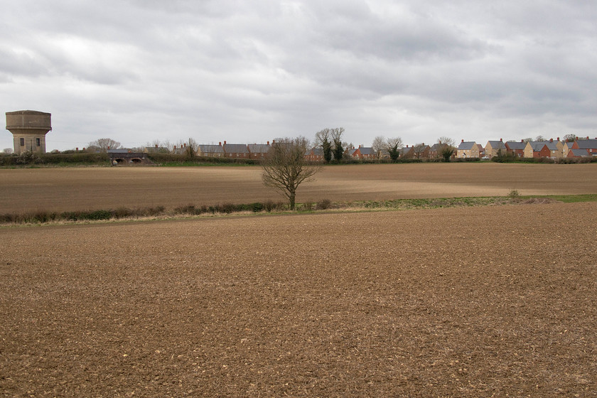 Route of SMJR & bridge, Roade 
 This view across the countryside very near to my home in Roade reveals a phenomenon that occurs a couple of times a year - the revealing of the route of the former Stratford-upon-Avon and Midland Junction Railway (SMJR) in the freshly ploughed field. With the farmer having just scrubbed out the oilseed rape that failed to flourish due to the incredibly wet winter, he has just ploughed the field and planted some spring barley. With the tilled soil just drying out a little shows the lighter strip where the line used to run emerging from the twin arch bridge on Ashton Road. It's amazing that over forty years after the line was abandoned and structures removed that the route still stands out in this manner. Google Earth also reveals the line again from the air but with further structures such as embankments and lines of trees for further reference. 
 Keywords: Route of SMJR bridge Roade Stratford-upon-Avon and Midland Junction Railway