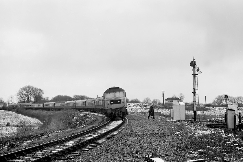 47069, outward leg of The Pines Express, 07.48 London Paddington-Weymouth (via Bristol & various freight lines), Bradford North Junction 
 Having brought his train to a halt, the driver of The Pines Express walks across to the tablet exchange equipment in the white hut. Once exchanged, his train will be able to proceed on to the Avon Valley line and continue its journey to Bath and Bristol. Notice the area of ballast where the driver is walking and the distance the signal post is from the track. This is because the line was once double track but has been singled. The remaining spur was completely removed in 1990, but there is consideration being given to its reinstatement due to the strategic importance of the line to and from Chippenham as a diversionary route. 
 Keywords: 47069 The Pines Express 07.48 London Paddington-Weymouth Bradford North Junction