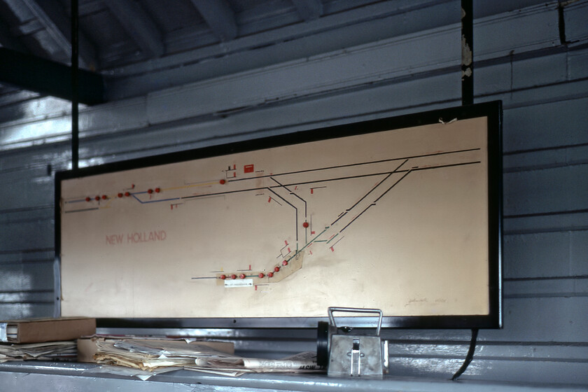 Track diagram, New Holland Town signal box 
 With the requisite Bardic lamp on the shelf along with various paperwork, the track diagram inside New Holland signal box is seen. The signalman kindly permitted Graham and I access to the box which was to close exactly a week later along with the line that led the short distance from here to the end of New Holland Pier. The line stretching to the bottom of the track diagram was the Barton-on-Humber branch that was temporarily out of use at this time in preparation for the new service offereed by BR to link up with busses that would carry passengers over the soon to opened Humber bridge in leiu of the Humber ferry. 
 Keywords: Track diagram New Holland Town signal box