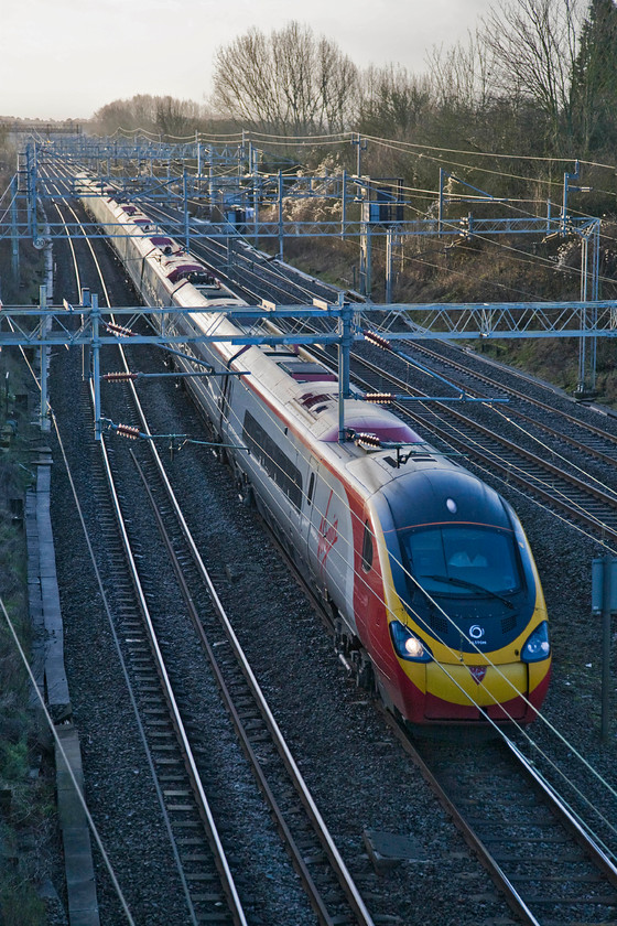 Class 390, VT 07.30 London Euston-Glasgow Central (1S42), diverted on the slow, Victoria bridge 
 A Virgin Pendolino heads north past Victoria bridge just south of Roade on the slow line meaning that it was to be routed via Northampton rather than the more normal Weedon route. Apparently, a track defect was reported on the Weedon line that was being assessed and, if necessary, repaired before trains could be allowed on it again. 
 Keywords: Class 390 VT 07.30 London Euston-Glasgow Central 1S42 Victoria bridge Virgin Trains Pendolino