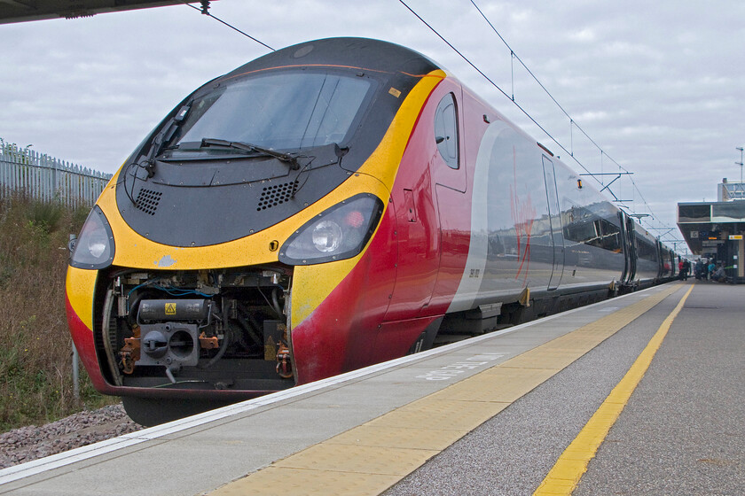 390002, VT 10.20 London Euston-Manchester Piccadilly (1H18), Milton Keynes station 
 In a style reminiscent of photographs that I took in my spotting youth, for example..... https://www.ontheupfast.com/p/21936chg/24037709204/b578-weymouth-bristol-temple-meads 390002 'Virgin Angel' pauses at Milton Keynes. With its coupling cover open exposing the innards to the elements it is about leave working the 1H18 10.20 Euston to Manchester Piccadilly but, at least this is the tail end of the train. 
 Keywords: 390002 10.20 London Euston-Manchester Piccadilly 1H18 Milton Keynes station Virgin Angel