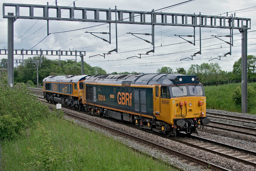 50007 & 66737, 13.00 Stewart's Lane-Kidderminster SVR (0Z63, 6E), between Roade & Ashton 
 Following VSOE charter duties yesterday the duo of GBRf locomotives head back to their respective bases. 50007 'Hercules' masquerading as 50014 'Warspite' (on this side at least) leads 66737 'Lesia' on the approach to Roade in Northamptonshire. The locomotives were heading back to the Severn Valley Railway as the 0Z63 that had left Stewert's Lane at 13.00. On arrival at Kidderminster (SVR) 66737 would detach and then head on its own to Doncaster's Down Decoy yard. For once, I was blessed with the sun not being out as if it had been this photograph would have been virtually impossible due to me facing south west, the gamble paid off! 
 Keywords: 50007 66737 13.00 Stewart's Lane-Kidderminster SVR 0Z63 between Roade & Ashton 50014 Warspite Hercules Lesia GBRf