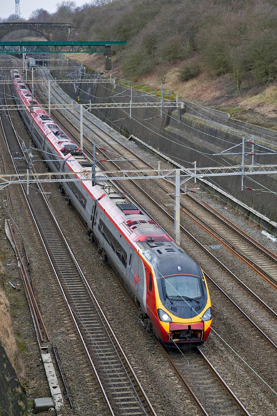 Class 390, VT 13.30 Birmingham New Street-London Euston (1B23), Roade cutting 
 With its nose cone coupler cover open an unidentified Pendolino heads south through Roade cutting working the 1B23 Birmingham New Street to Euston train. Note the last wagon of the 4M93 08.11 Felixstowe to Crewe Freightliner just going out of view on the down slow line. 
 Keywords: Class 390 VT 13.30 Birmingham New Street-London Euston 1B23 Roade cutting Virgin West Coast Pendolino