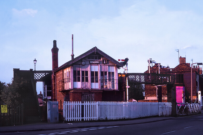 Spalding No.1 signal box (GN, 1921) 
 Another repeat photograph from last year's summer trip, see..https://www.ontheupfast.com/p/21936chg/29682541404/spalding-no-1-signal-box-gn-1921 but this time it is taken in some pleasant evening sunshine rather than the grey overcast day the twelve months previously. The substantial Spalding Number 1 box was a Great Northern structure dating from 1921. It controlled the station and access to it from the south as well as operating the crossing gates on the busy Winsover Road. As can be seen, a footbridge was provided for pedestrians to cross the line when the gates were closed to road users. The box was closed in 2014 and demolished shortly after that with barriers now controlling the crossing. The footbridge has also been removed. 
 Keywords: Spalding No.1 signal box GN 1931 Great Northern